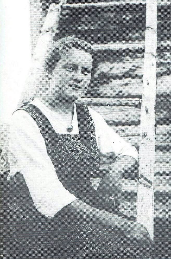Anna Mathilda Barski seated outside a wooden building