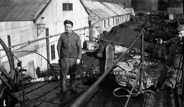 Hans beside a pier. Hans is the man center left. Identification supplied by the family. Vessel, location and date remain unconfirmed.