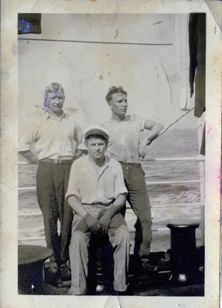 Three sailors on ship, view 2. Hans is on the right. Identification supplied by the family. Vessel, location and date remain unconfirmed. The colorized interpretation changes parts of the background; consult the original for the historical setting.