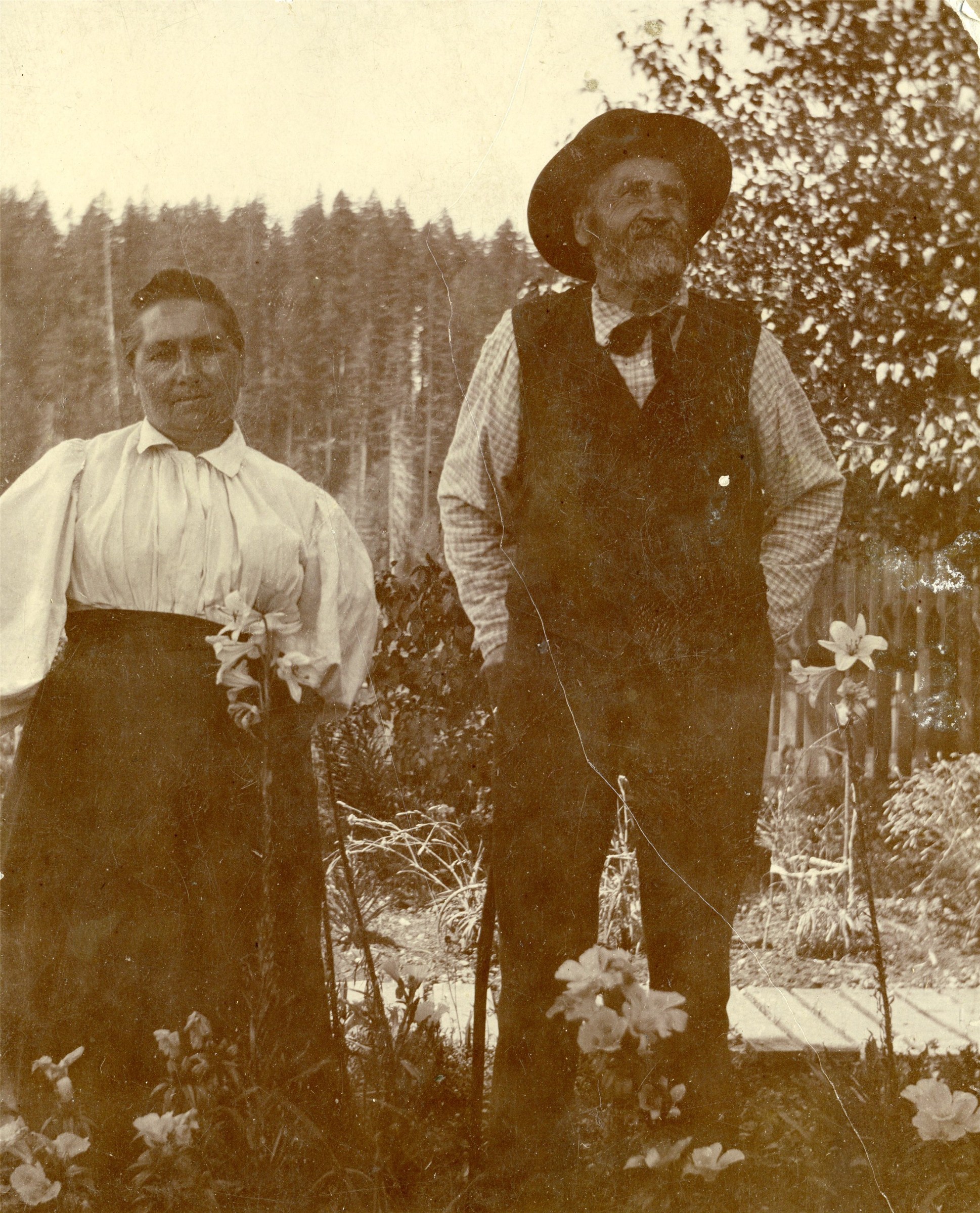 A closer view of Magdalena and David August Hilpert standing among flowers